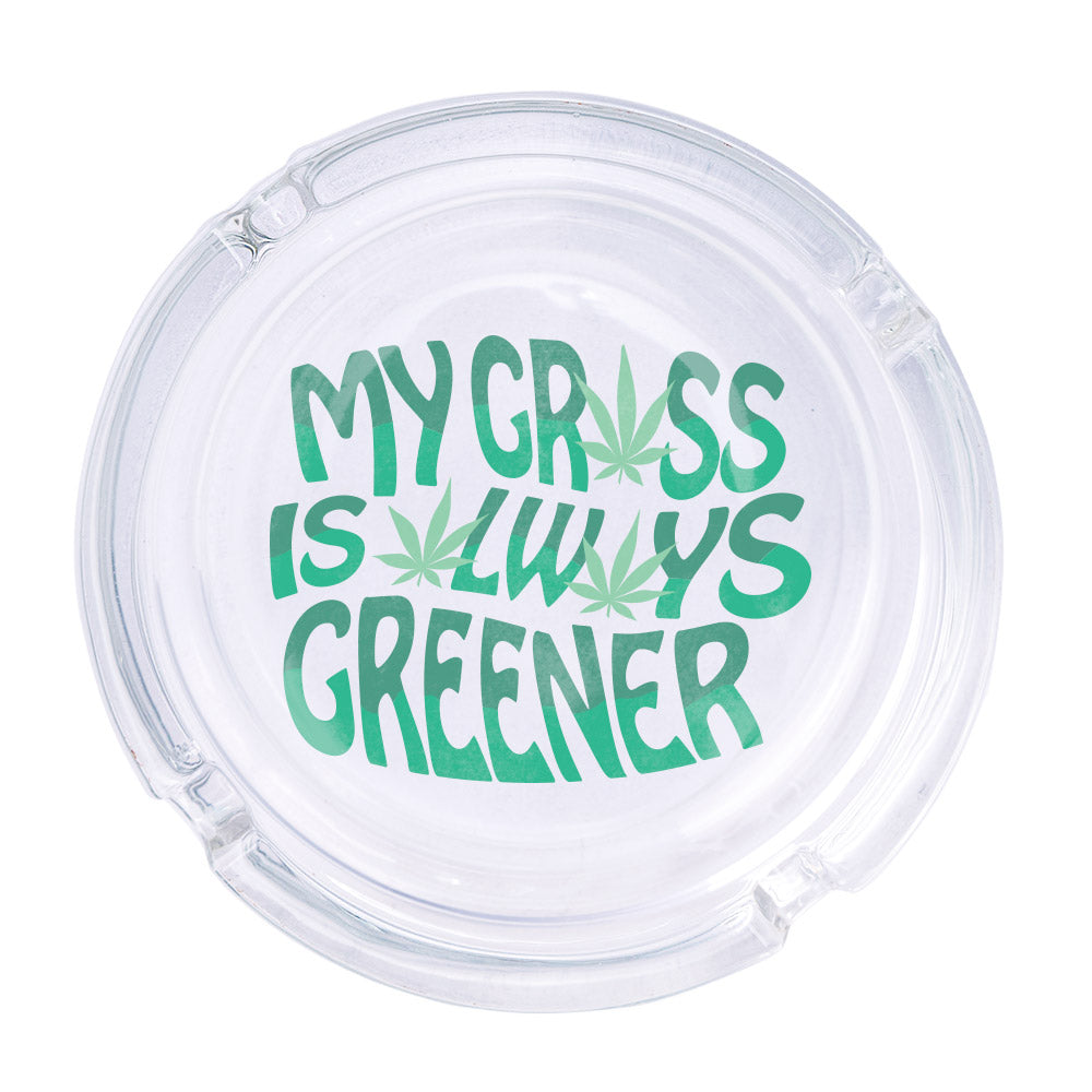 Always Greener Ashtray - Femfetti - A clear glass ashtray featuring the phrase &quot;My grass is always greener&quot; in green text with weed leaves.