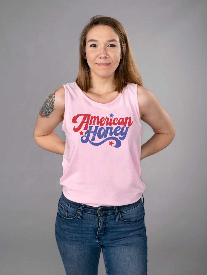 American Honey Tank Top - Femfetti - A pink color unisex fit graphic tank top featuring the phrase &quot;American Honey&quot; in red and blue retro text.