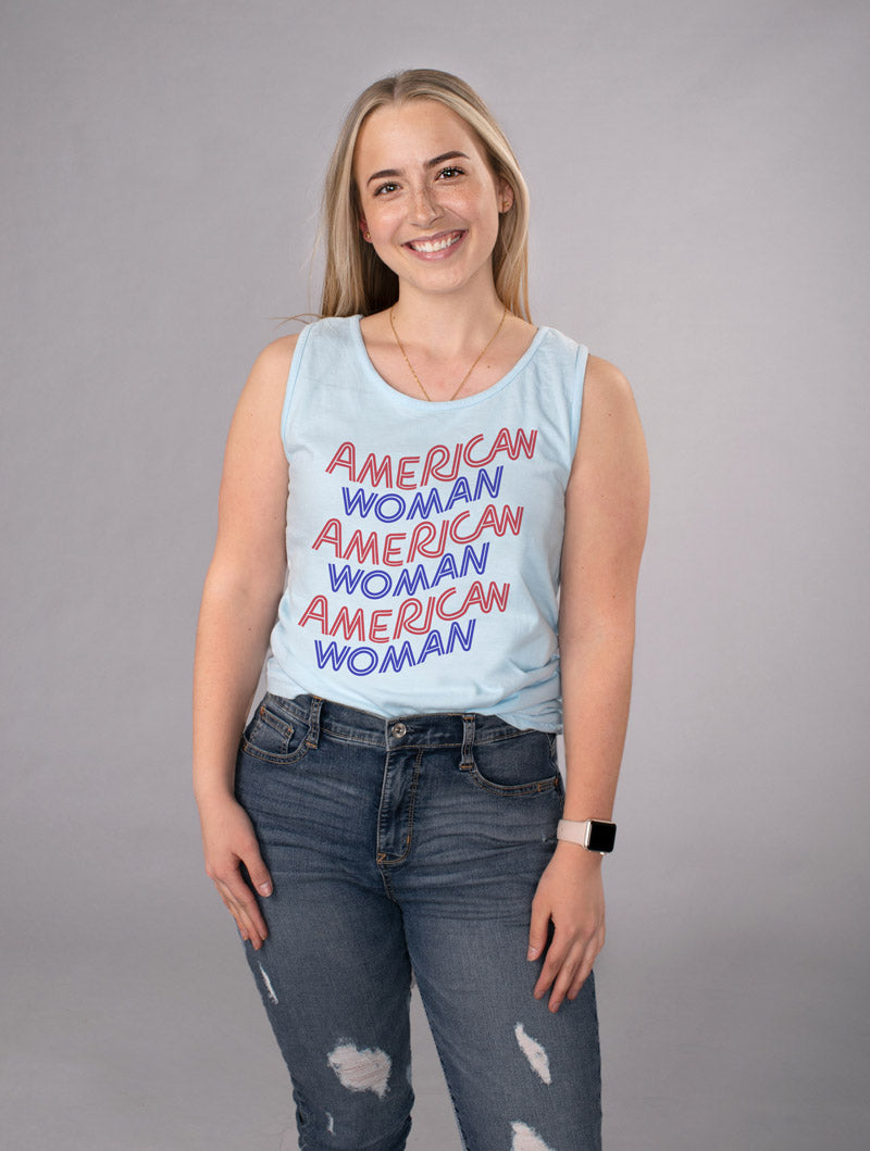 American Woman Tank Top - Femfetti - A light blue color unisex fit graphic tank top featuring the phrase &quot;American Woman&quot; in red and blue retro style text.