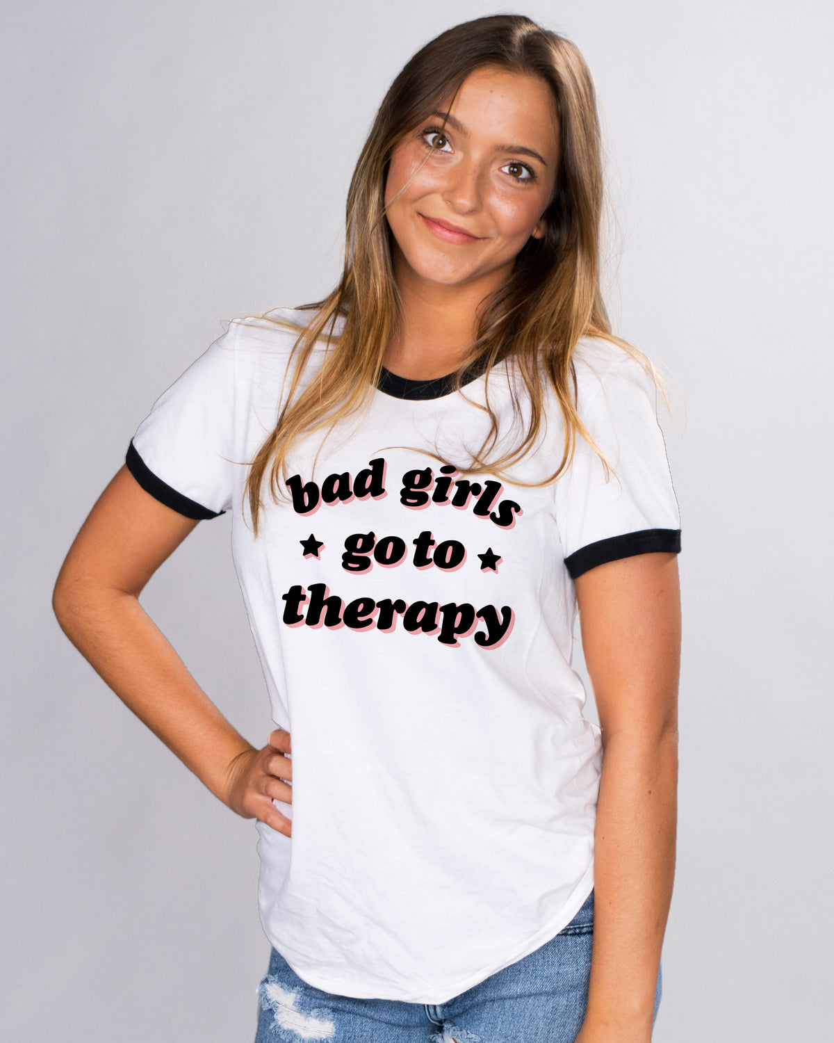Bad Girls Go To Therapy Ringer Tee - Femfetti - A white and black unisex fit ringer tee shirt featuring the phrase &quot;bad girls go to therapy&quot; in black and pink font.